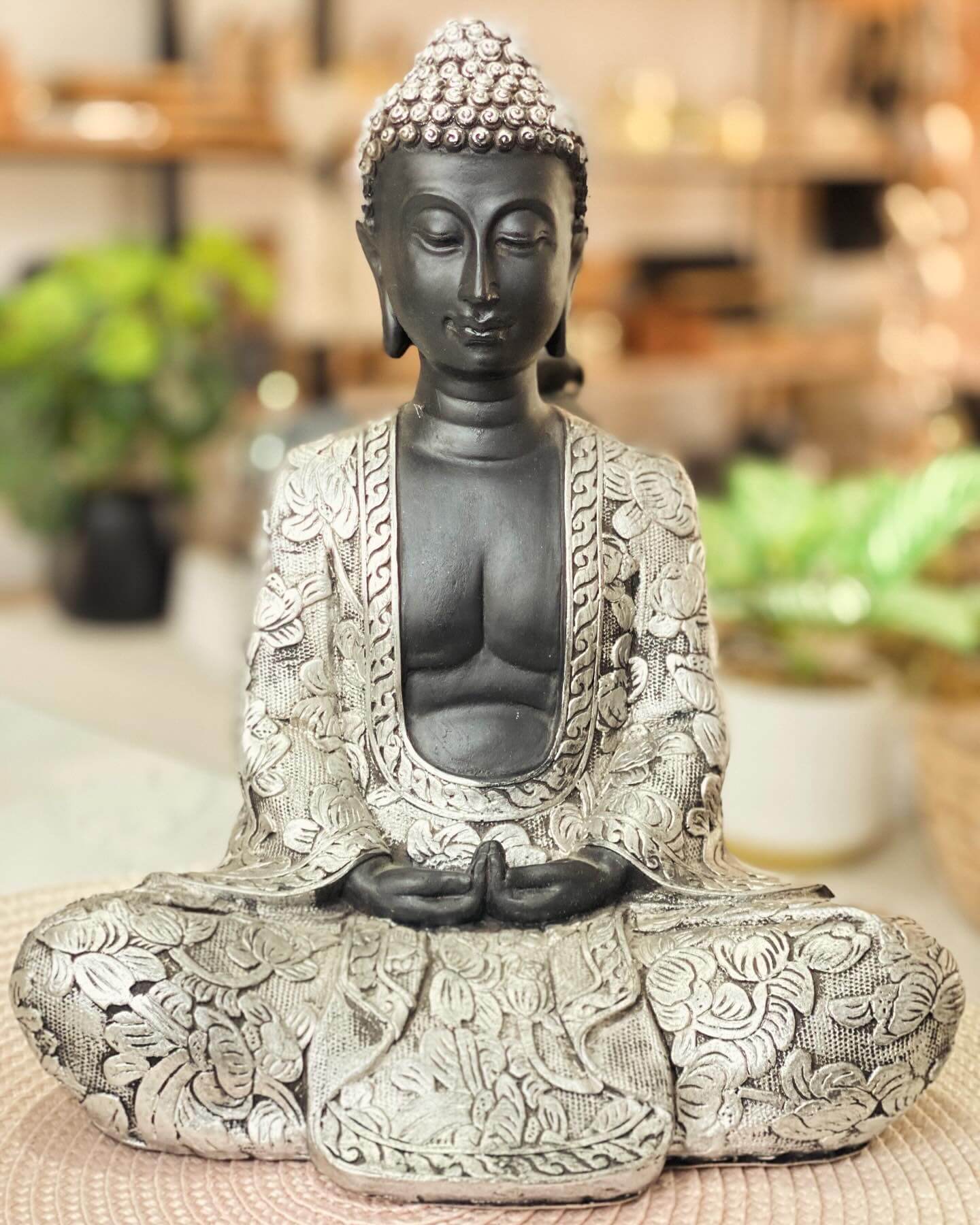 Figura de buda grande con ropa gris con trama de flores y arabescos
