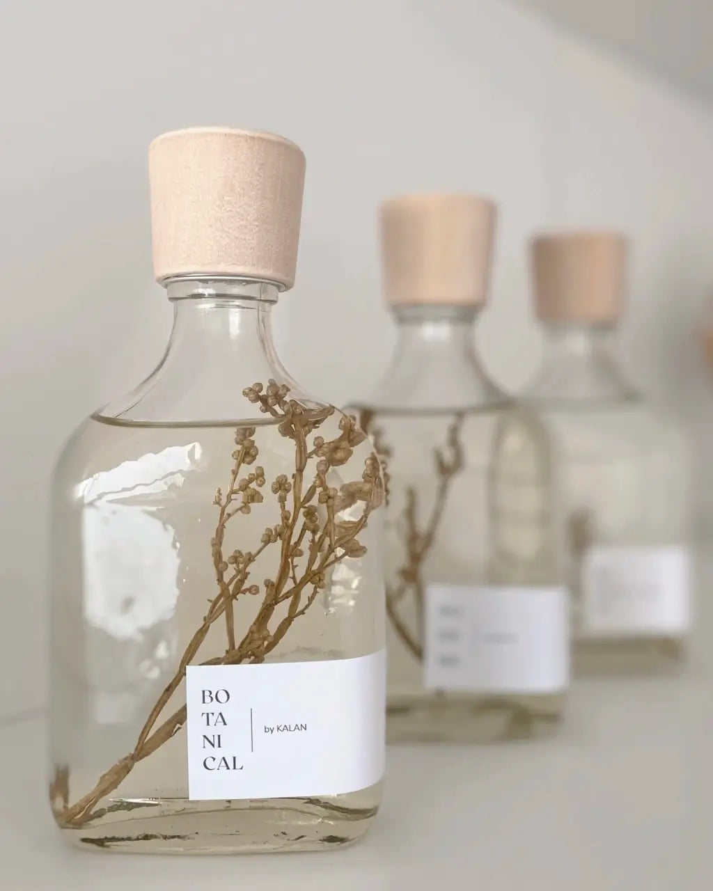 Difusor aromático con tapa de madera y ramitas de flores secas dentro.