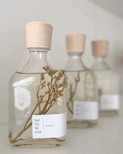 Difusor aromático con tapa de madera y ramitas de flores secas dentro.